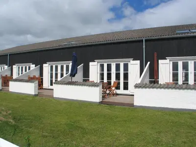 a black building with a patio and a house at Apartment Dineke - 200m to the fjord by Interhome in Vestervig