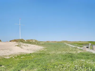 a windmill on top of a field with a dirt road at Apartment Dineke - 200m to the fjord by Interhome in Vestervig