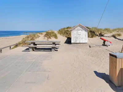 a bench and a small shack on the beach at Apartment Dineke - 200m to the fjord by Interhome in Vestervig