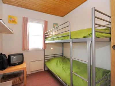 a bunk bed room with two bunk beds and a desk at Apartment Stelle - 100m to the fjord by Interhome in Vestervig