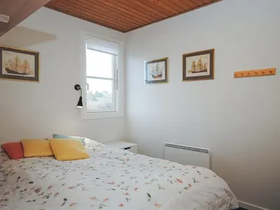 a bedroom with a bed and a window at Apartment Stelle - 100m to the fjord by Interhome in Vestervig