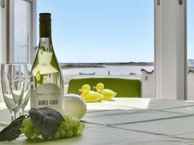 a bottle of wine sitting on a table with grapes at Apartment Siunde - 100m to the fjord by Interhome in Vestervig
