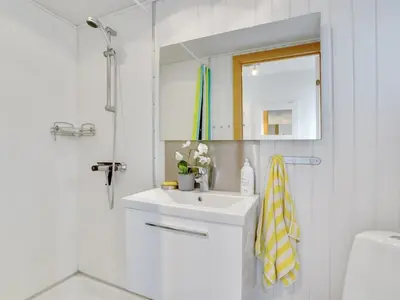 a white bathroom with a sink and a mirror at Apartment Siunde - 100m to the fjord by Interhome in Vestervig