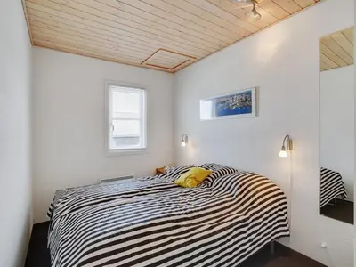 a bedroom with a black and white striped bed at Apartment Siunde - 100m to the fjord by Interhome in Vestervig