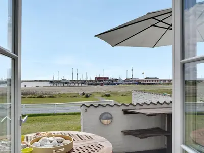 a view of the beach from a window with an umbrella at Apartment Siunde - 100m to the fjord by Interhome in Vestervig