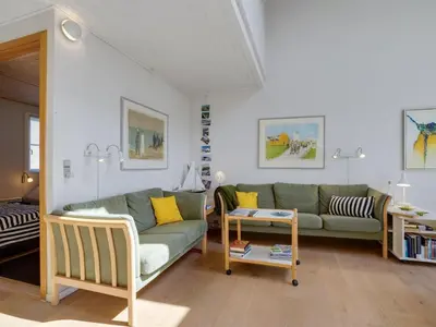 a living room with a green couch and yellow pillows at Apartment Siunde - 100m to the fjord by Interhome in Vestervig