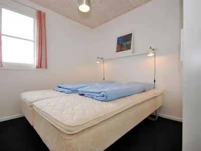 a white bedroom with a bed with blue sheets at Apartment Benta - 150m to the fjord by Interhome in Vestervig
