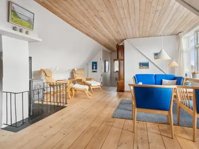 a living room with a wooden ceiling and blue chairs at Holiday Home Gertina - 40m to the fjord by Interhome in Vestervig