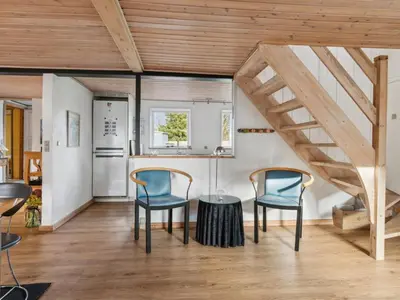 a kitchen with a table and two chairs and a staircase at Holiday Home Gertina - 40m to the fjord by Interhome in Vestervig