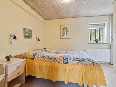 a bedroom with a bed and a dresser at Holiday Home Gertina - 40m to the fjord by Interhome in Vestervig