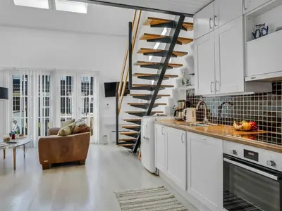 a kitchen with white cabinets and a spiral staircase at Apartment Eleen - 100m to the fjord by Interhome in Vestervig