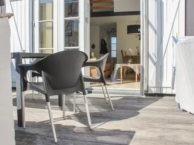 a black chair sitting next to a table in a room at Apartment Eleen - 100m to the fjord by Interhome in Vestervig