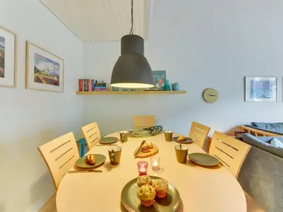 a dining room with a table and chairs with food on it at Apartment Cita - 100m to the fjord by Interhome in Vestervig