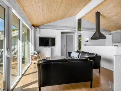 a living room with a couch and a tv at Holiday Home Sulevi - 200m to the fjord by Interhome in Vestervig
