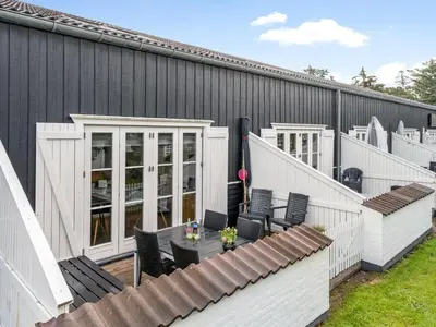 a patio with a table and chairs and a building at Apartment Hermanda - 100m to the fjord by Interhome in Vestervig
