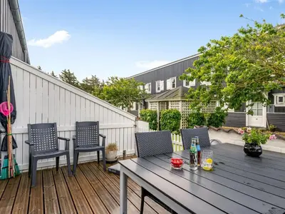 a wooden deck with a wooden table and chairs at Apartment Hermanda - 100m to the fjord by Interhome in Vestervig