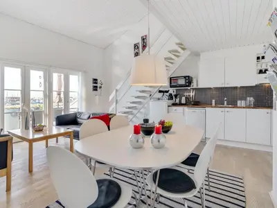 a kitchen and living room with a white table and chairs at Apartment Idunn - 100m to the fjord by Interhome in Vestervig