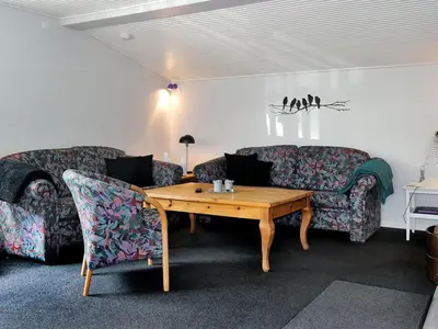 a living room with two couches and a wooden table at Holiday Home Assarina - 300m to the fjord by Interhome in Vinderup