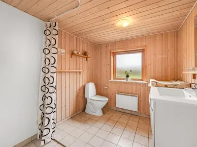 a bathroom with a toilet and a sink at Holiday Home Scarlet - 400m to the fjord by Interhome in Vinderup