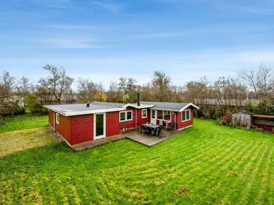 a red tiny house in a grassy yard at Holiday Home Scarlet - 400m to the fjord by Interhome in Vinderup