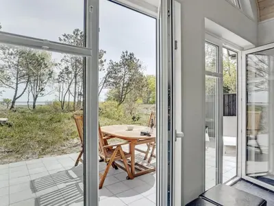 a glass door leading to a patio with a table at Holiday Home Angelita - 80m to the fjord by Interhome in Thyholm