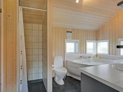 a bathroom with a tub and a toilet and a sink at Holiday Home Brynjolf - 350m to the fjord by Interhome in Vinderup