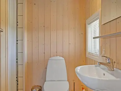 a bathroom with a white toilet and a sink at Holiday Home Brynjolf - 350m to the fjord by Interhome in Vinderup