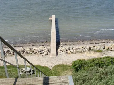 a lighthouse on the beach with a group of sheep at Holiday Home Brynjolf - 350m to the fjord by Interhome in Vinderup