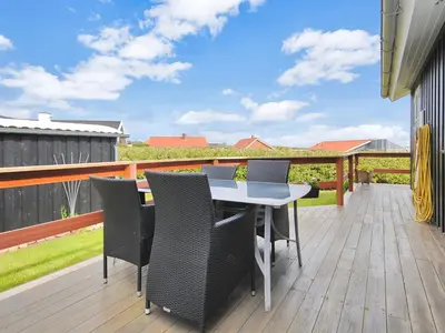 a patio with a table and chairs on a deck at Holiday Home Eberta - 200m to the fjord by Interhome in Vinderup