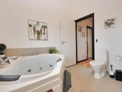 a white bathroom with a tub and a toilet at Holiday Home Eberta - 200m to the fjord by Interhome in Vinderup