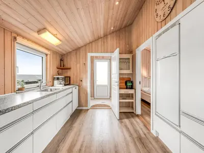 a kitchen with white cabinets and a wooden ceiling at Holiday Home Loviisa - 300m to the fjord by Interhome in Vinderup
