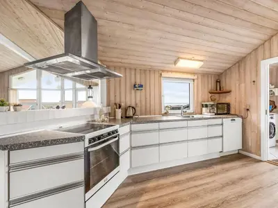 a kitchen with white cabinets and a stove top oven at Holiday Home Loviisa - 300m to the fjord by Interhome in Vinderup