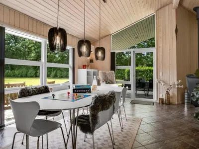 a dining room with a white table and chairs at Holiday Home Yorrit - 500m to the fjord by Interhome in Højslev