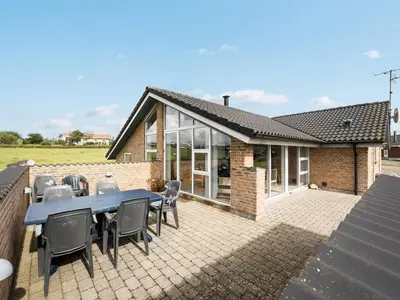 a house with a patio with a table and chairs at Holiday Home Alboldus - 250m to the fjord by Interhome in Vinderup