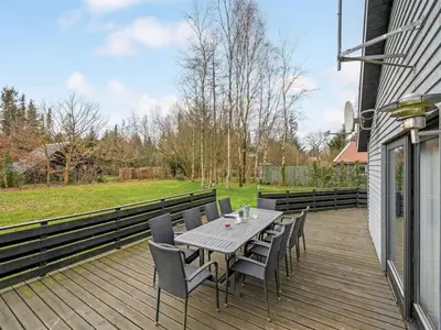 a wooden deck with a table and chairs on it at Holiday Home Anine - 200m to the fjord by Interhome in Højslev