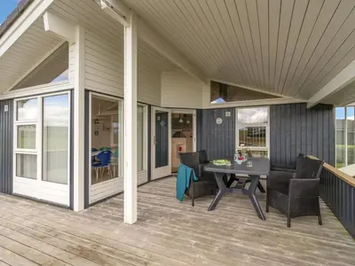 a screened porch with a table and chairs on it at Holiday Home Lucio - 350m to the fjord by Interhome in Vinderup