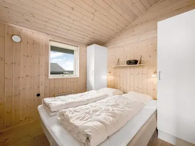 a large bed in a wooden room with a window at Holiday Home Lucio - 350m to the fjord by Interhome in Vinderup