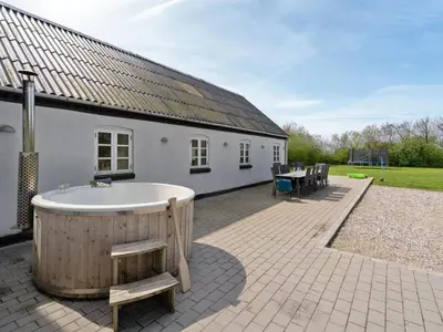 a large tub sitting outside of a white building at Holiday Home Folkar - 3km to the fjord by Interhome in Thyholm