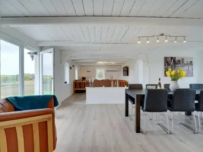 a dining room and living room with a table and chairs at Holiday Home Ailke - 2km to the fjord by Interhome in Thyholm