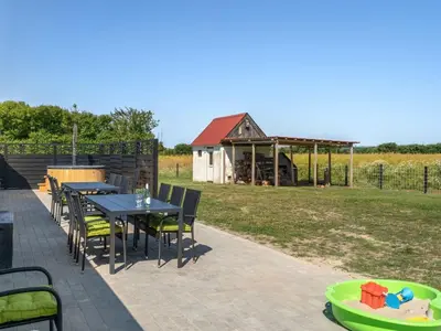 a patio with a table and chairs and a barn at Holiday Home Ailke - 2km to the fjord by Interhome in Thyholm