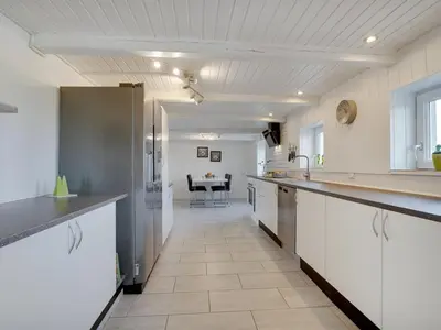 a large kitchen with white cabinets and a table at Holiday Home Ailke - 2km to the fjord by Interhome in Thyholm