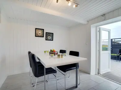 a dining room with a white table and chairs at Holiday Home Ailke - 2km to the fjord by Interhome in Thyholm