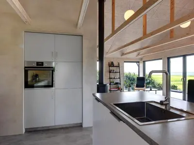 a kitchen with white cabinets and a sink at Holiday Home Aslag - 150m to the fjord by Interhome in Vinderup