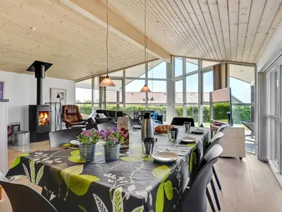 a dining room with a long table with flowers on it at Holiday Home Guthmar - 350m to the fjord by Interhome in Vinderup