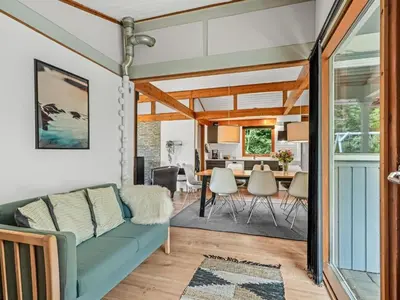 a living room with a couch and a dining room at Holiday Home Gudfast - 300m to the fjord by Interhome in Thyholm