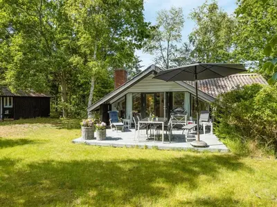 a patio with an umbrella and a table and chairs at Holiday Home Alika - 200m to the fjord by Interhome in Thyholm