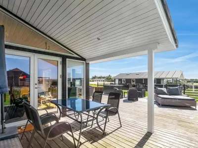 a patio with a table and chairs on a deck at Holiday Home Ginia - 150m to the fjord by Interhome in Vinderup
