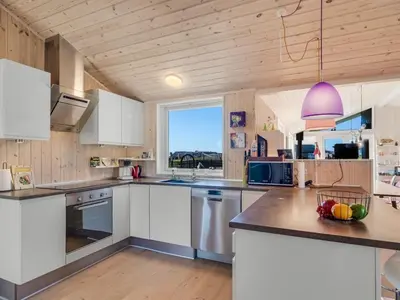 a kitchen with white cabinets and a pink light fixture at Holiday Home Ginia - 150m to the fjord by Interhome in Vinderup