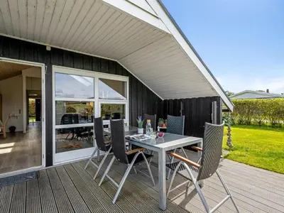 a patio with a table and chairs on a deck at Holiday Home Naninja - 300m to the inlet by Interhome in Vinderup