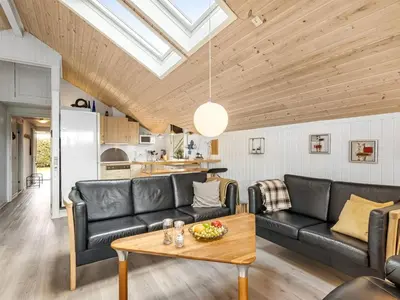a living room with black leather furniture and a wooden ceiling at Holiday Home Naninja - 300m to the inlet by Interhome in Vinderup